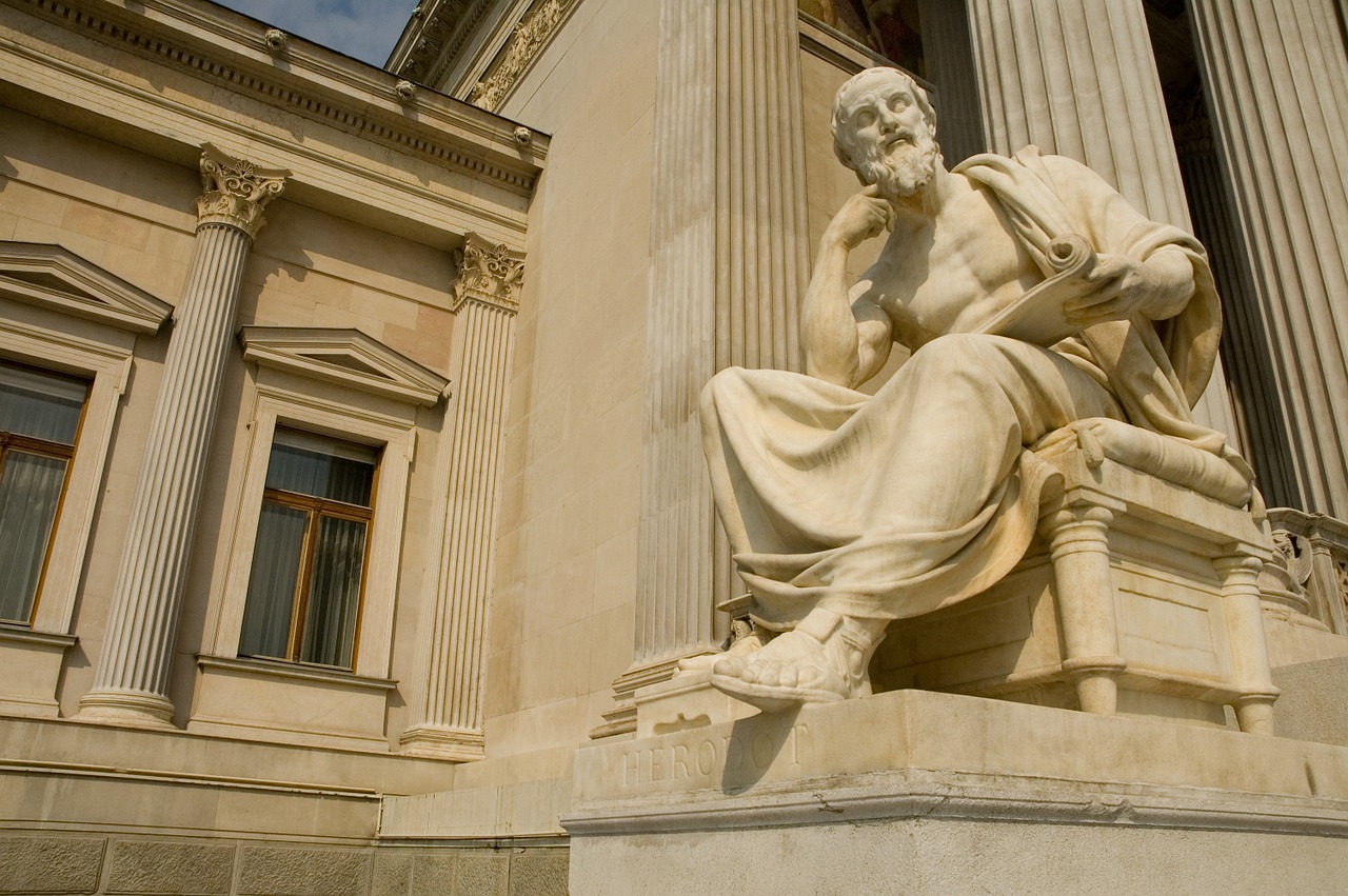 A statue of the Greek philosohper Herodotus in a thinking pose.